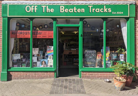 A photo of the outside of Off The Beaten Tracks record shop in Louth, which has a green storefront and records on display in the windows.