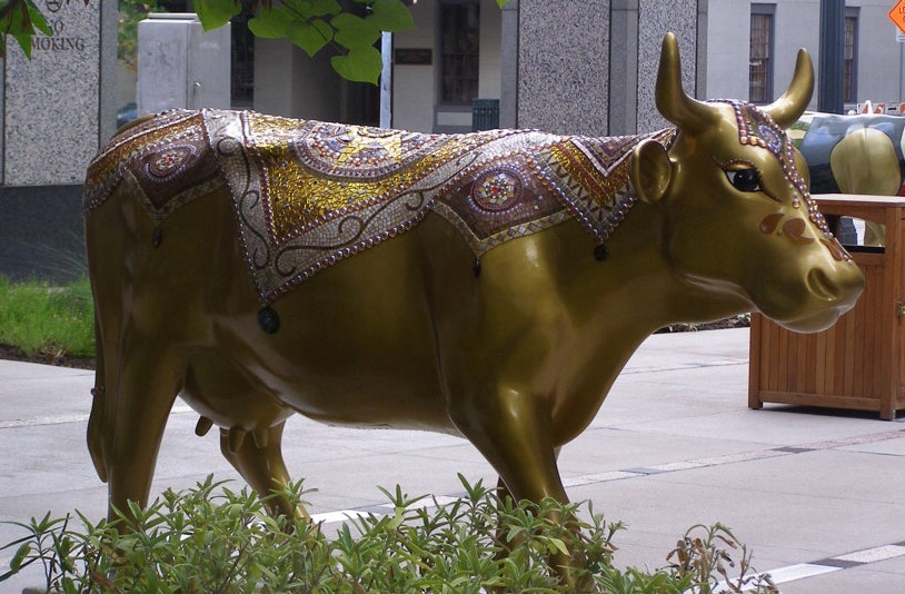 “Gilded Lily” by Dianne Sonenberg  was created for CowParade Austin, a public art exhibit and charitable auction.  She is life sized, and features metallic paint accented with mosaic blankets and embellishments.  Stained glass, glass tile and nuggets, millefiori, fused glass, and Spectralock Dazzle grout.