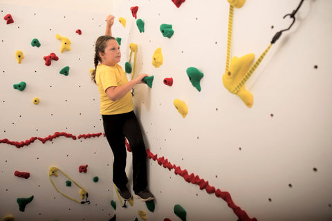 Girl rock climbing while avoiding areas of "thin ice" obstacles