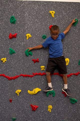 Boy climbing on a traverse wall