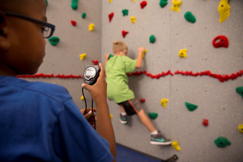 Boy rock climbing while being timed during a speed climbing activity