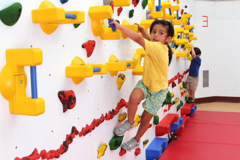 Girl climbing on an Adaptive Wall by Everlast Climbing