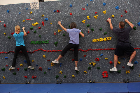 Teachers climbing on a school traverse wall