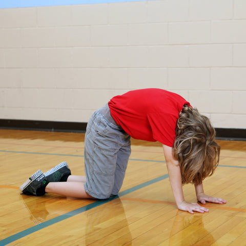 Boy doing yoga cat pose