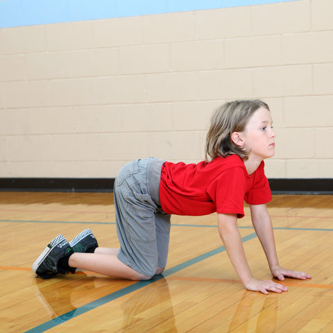 Boy doing yoga cow pose