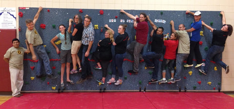 Everlast Climbing staff on the climbing wall they donated and installed at a school