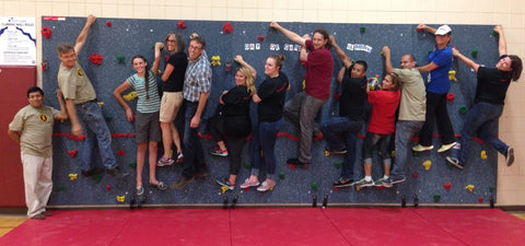 Everlast Climbing employees on a climbing wall they installed for their Day of Caring Program