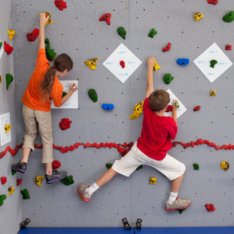 Children writing on Discovery Plates while rock climbing