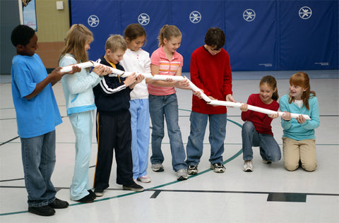 Children trying to move marbles through tubes as part of a teambuilding game called Don't Lose Your Marbles