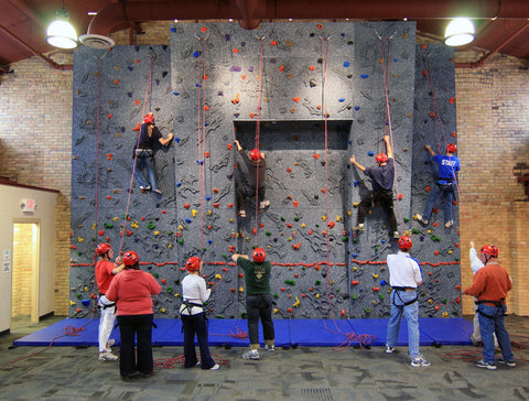 Traditional belay system being used on a vertical climbing wall to keep climbers safe