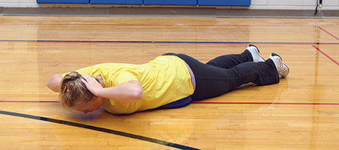 Girl performing back extension exercise on a balance disc