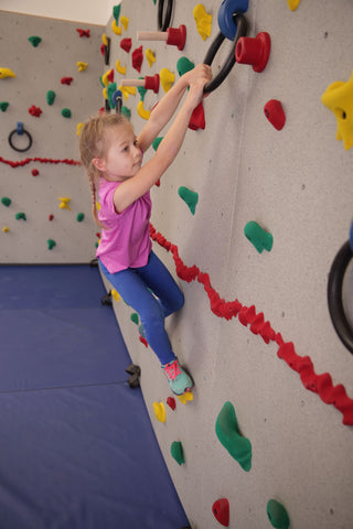 Girl rock climbing using Loop Holds by Everlast Climbing