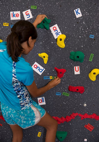 Girl Climbing and placing magnets on a Magna Wall by Everlast Climbing