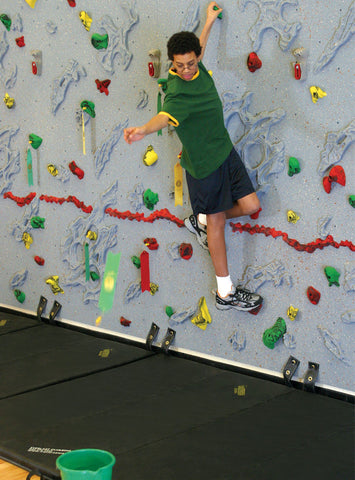 Boy tossing a Magna Flag while rock climbing