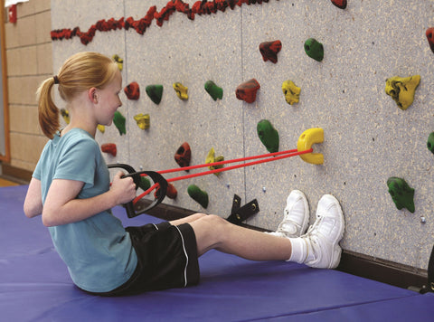 Girl doing a strength exercise using the StartFit System attached to a climbing wall