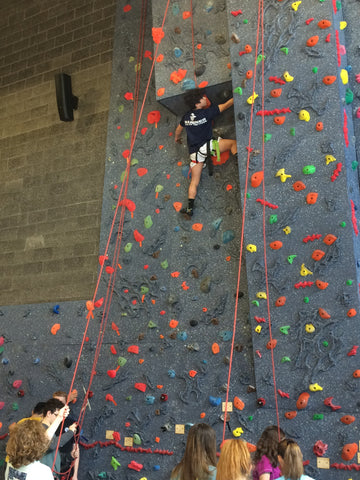 Boy climbing on a top rope climbing wall by Everlast Climbing