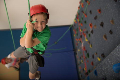 Boy rappelling from a top rope climbing wall