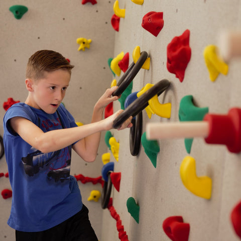 Boy rock climbing using the Ultimate Challenge Course