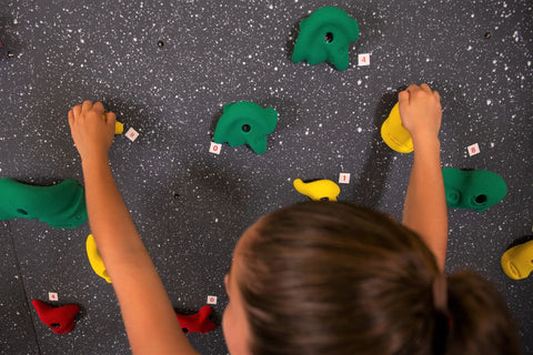 Girl rock climbing while finding numbers to create fact families