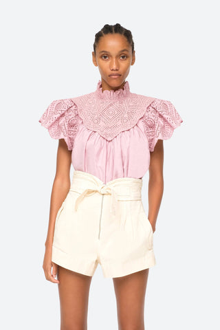 Vienne eyelet top in lilac with flutter sleeves, high ruffle neck and scalloped hem