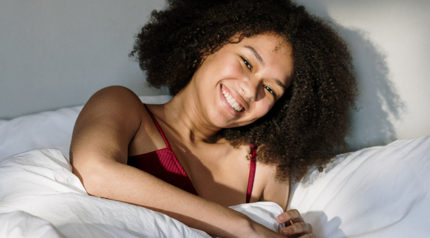 Eine Frau liegt lächelnd im Bett
