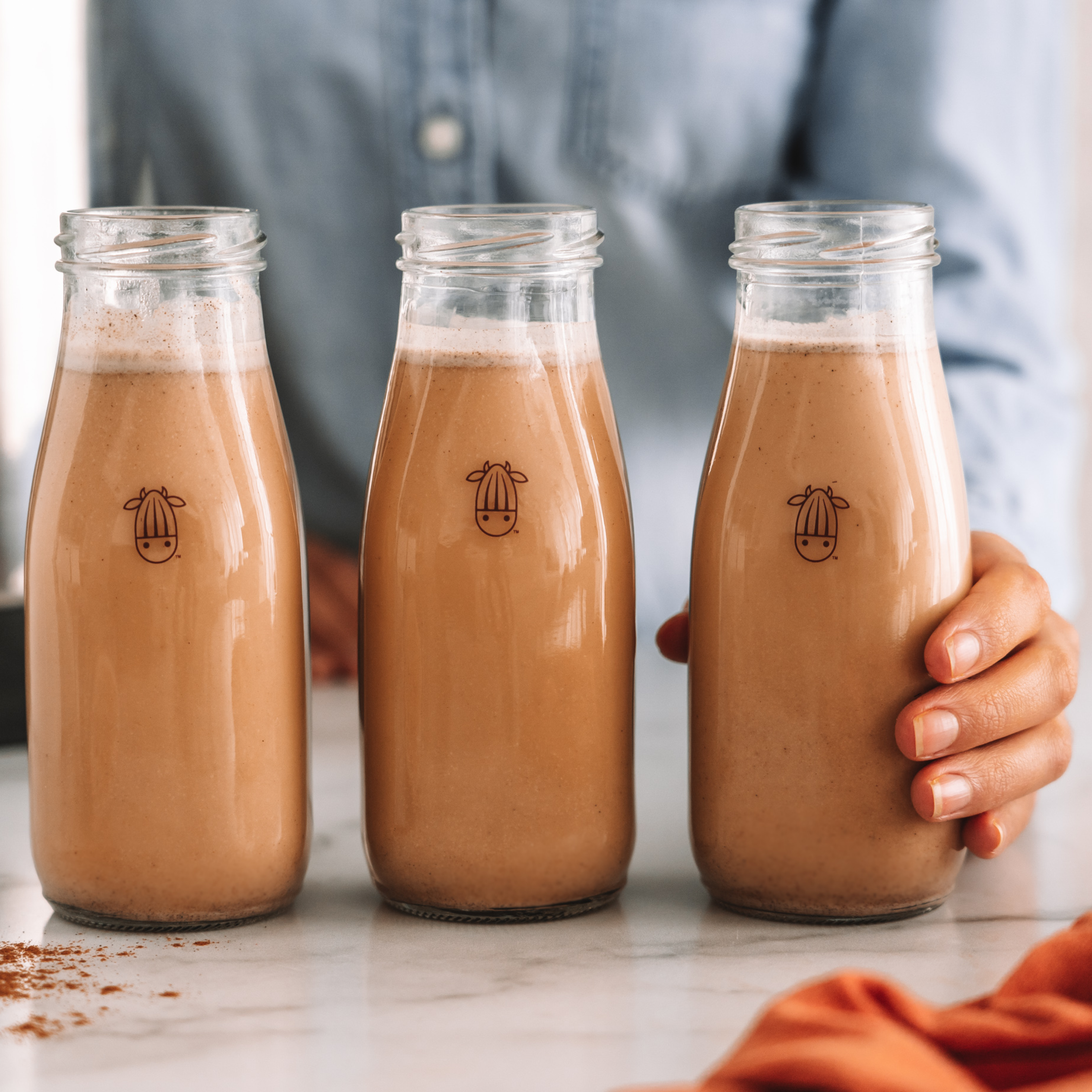 three bottles of plant-based carrot cake milk