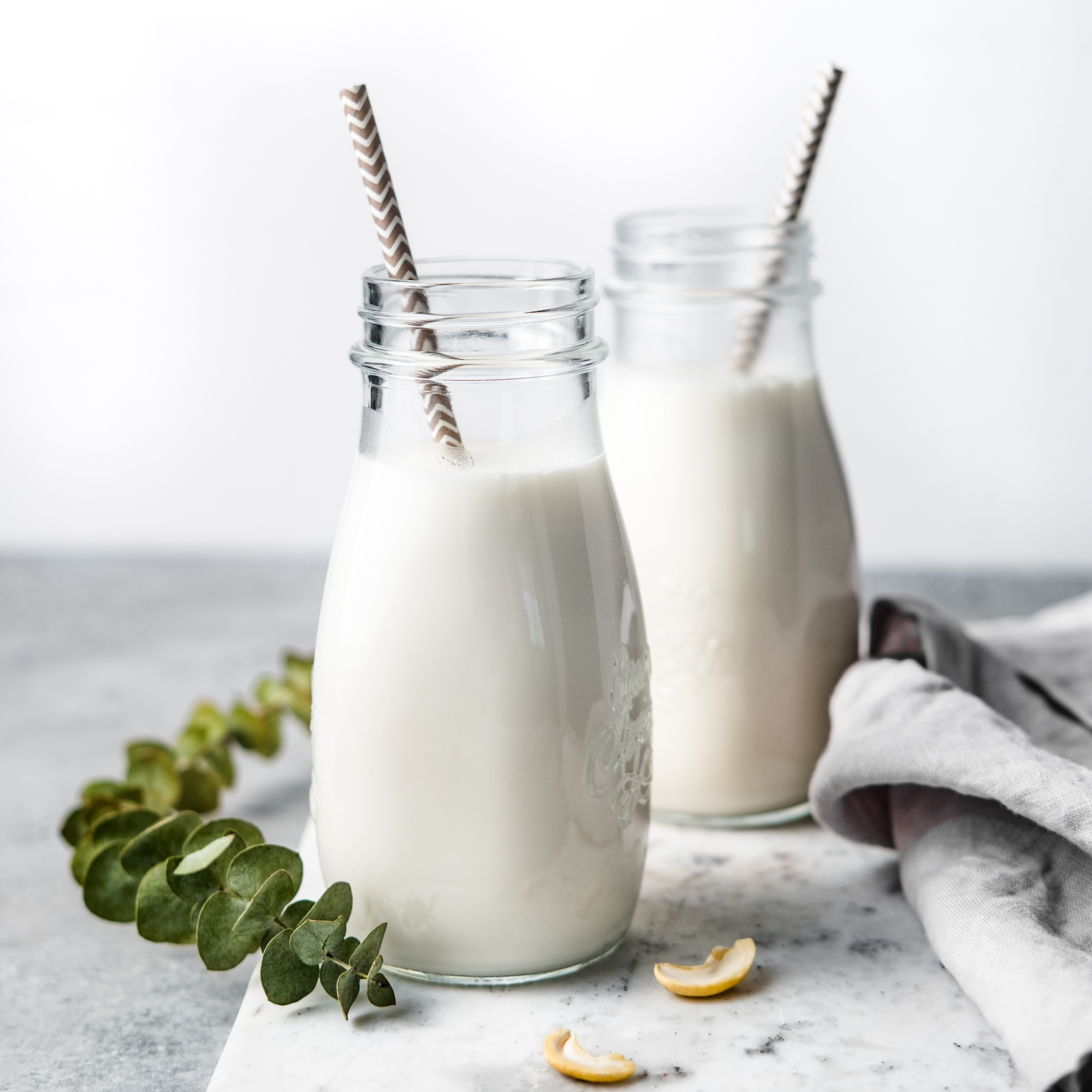 homemade, plant-based cashew milk in two glass bottles