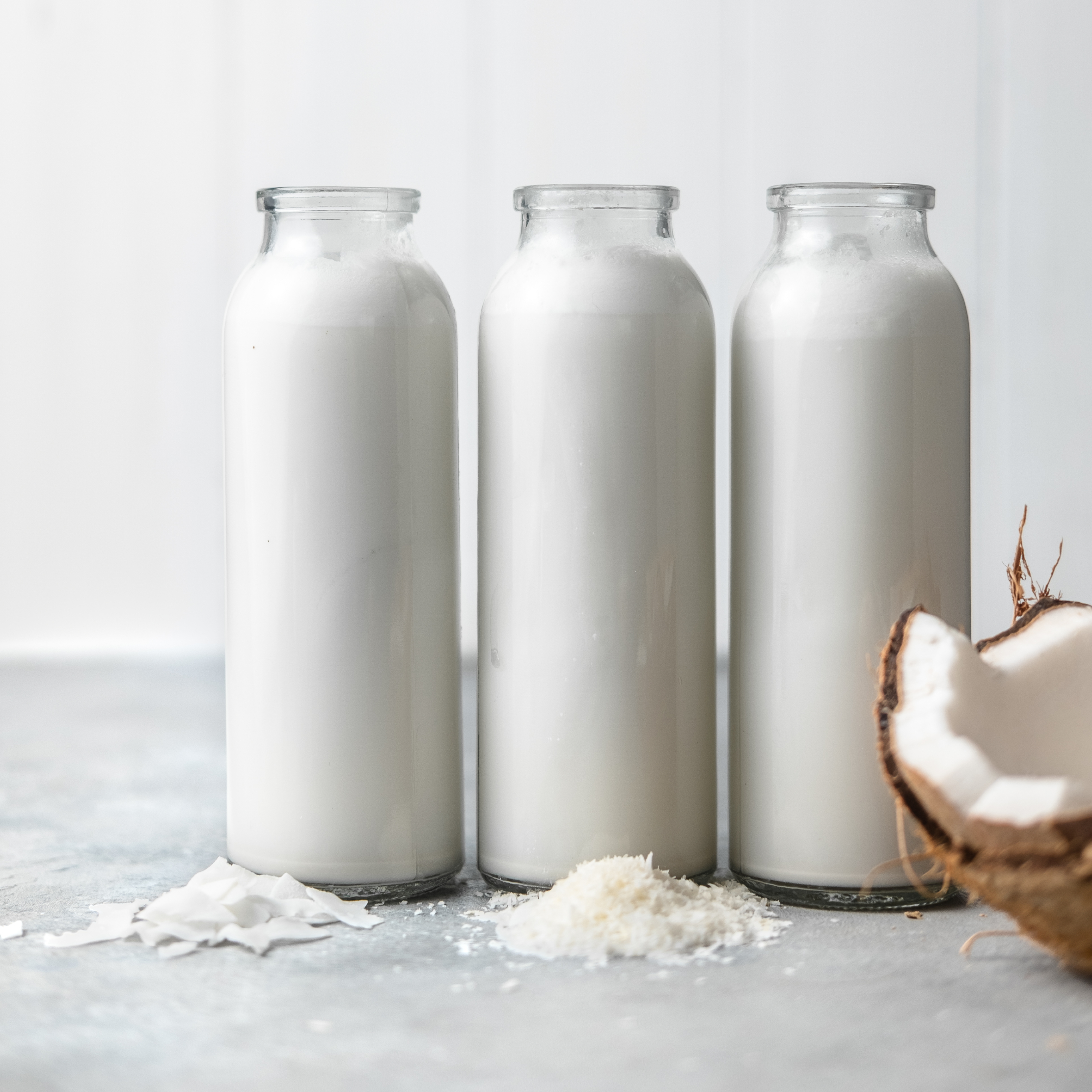 vegan coconut creamer in three glass bottles