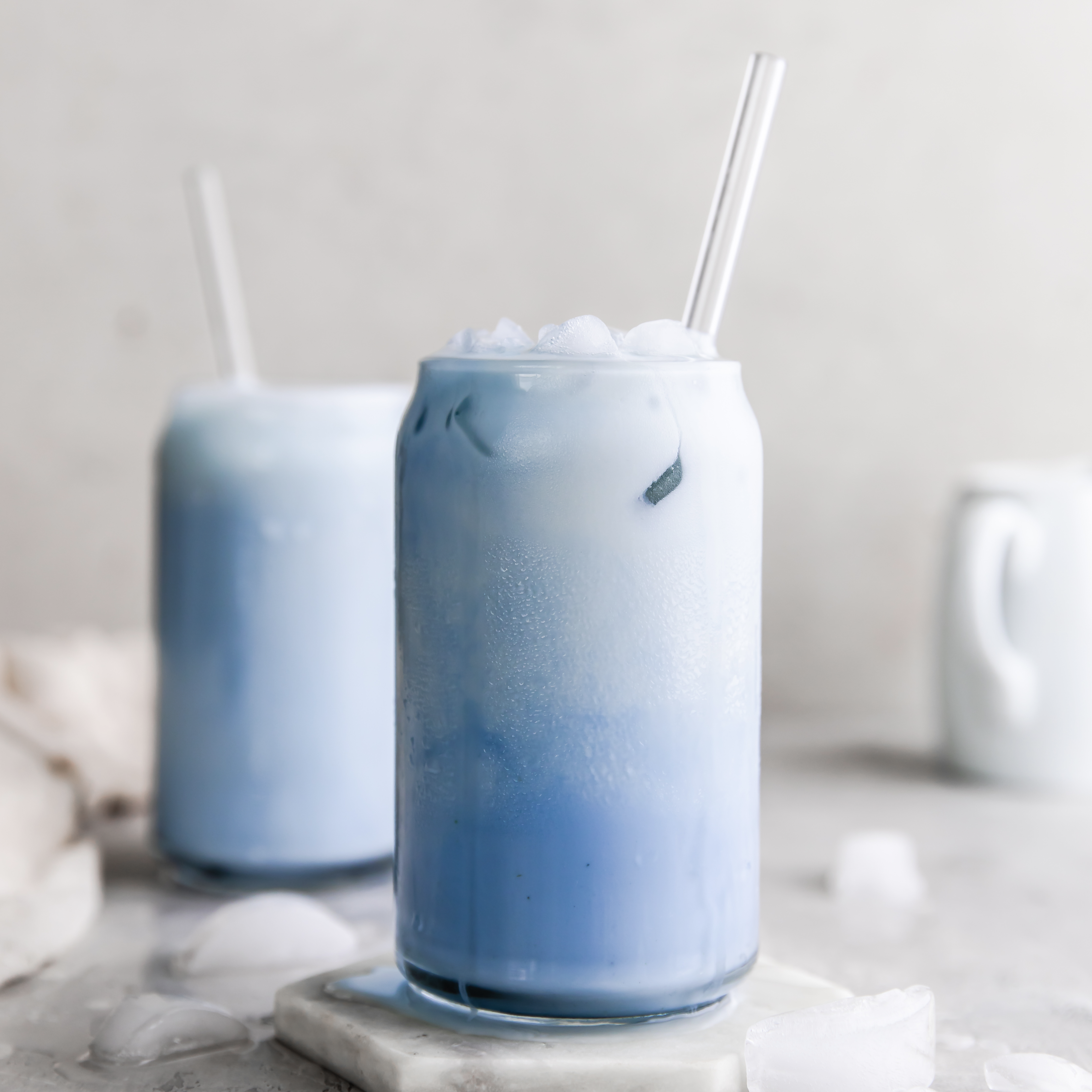 glass of plant-based iced blue milk with a straw