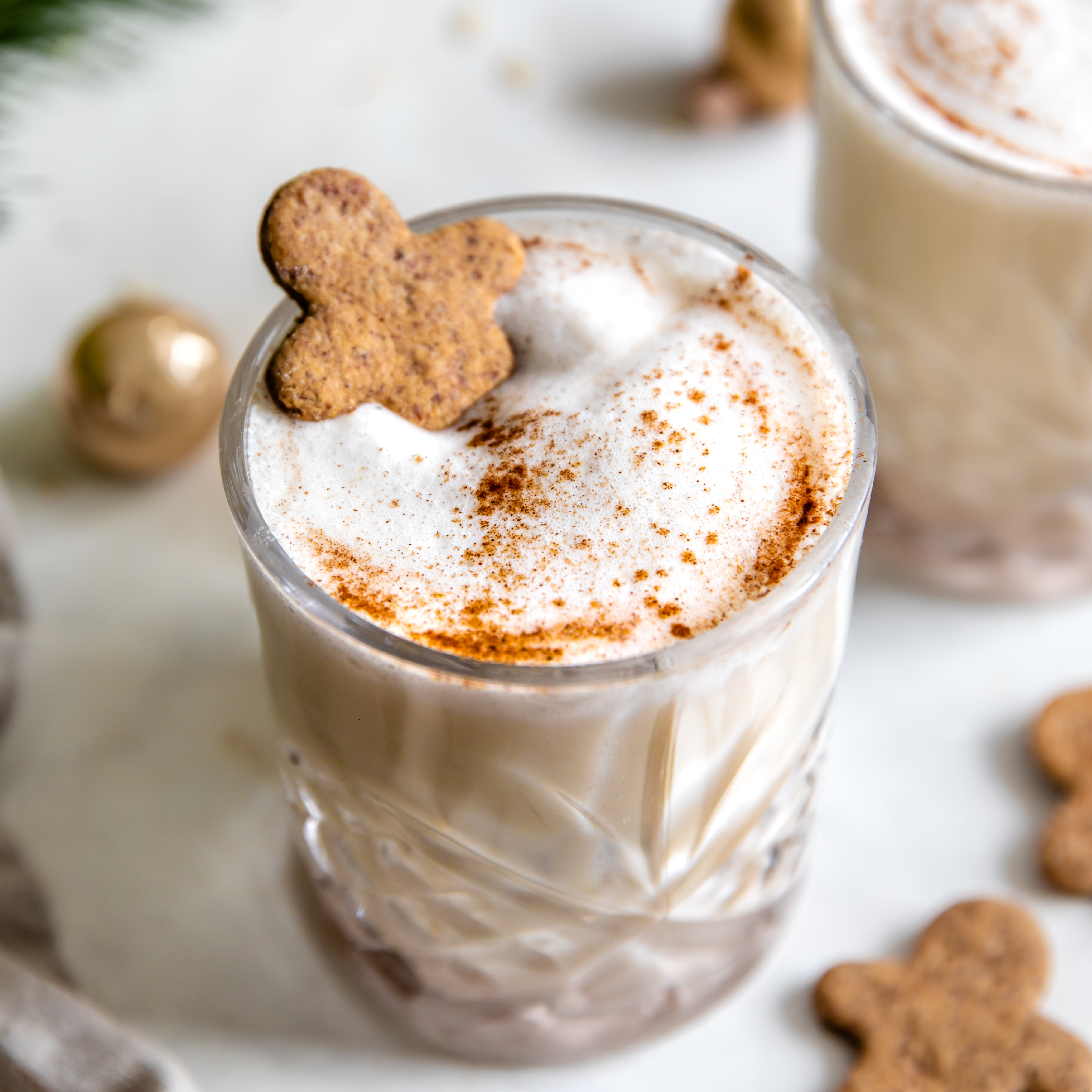 a glass of vegan oatnog with a gingerbread man