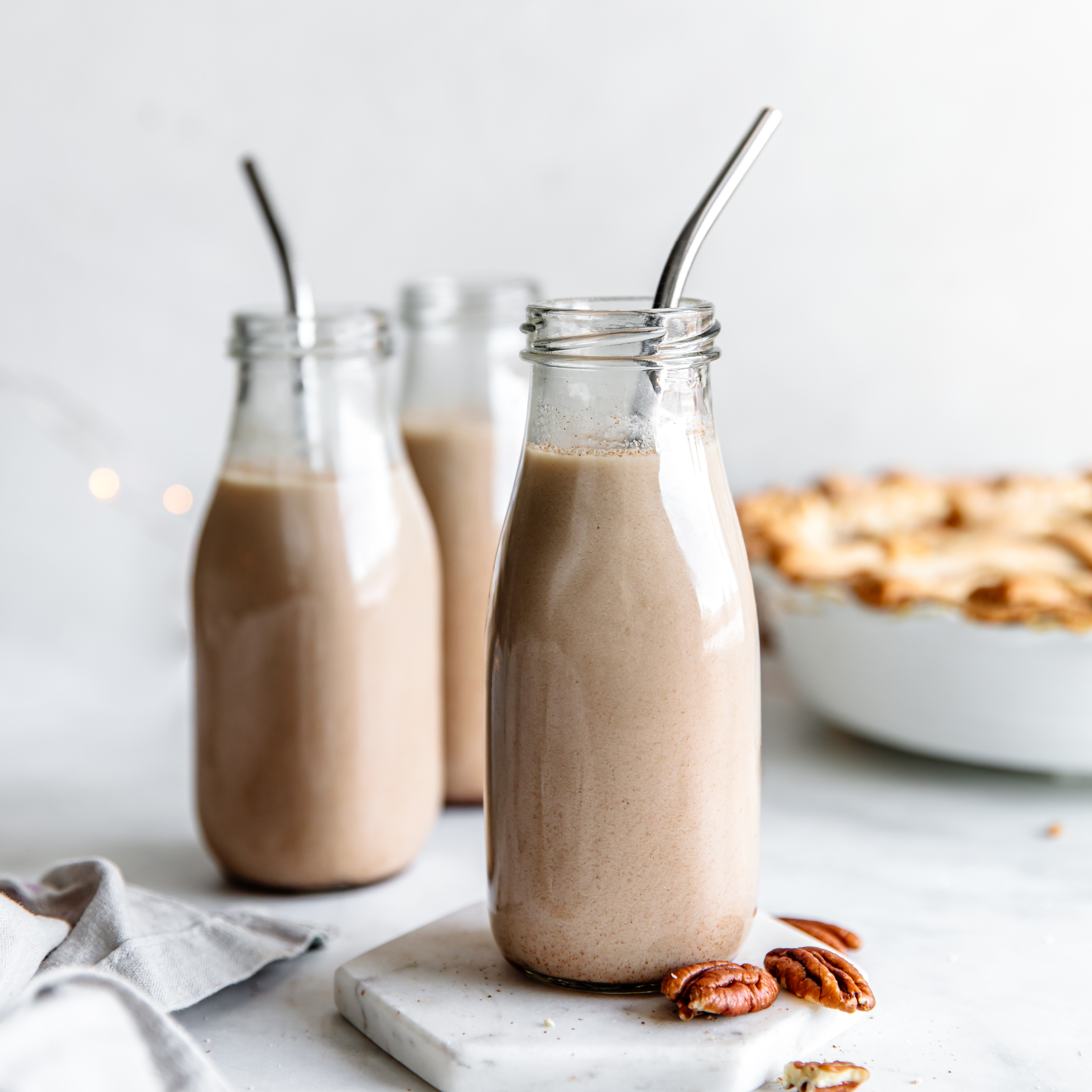 vegan pecan pie milk in a glass with a metal straw