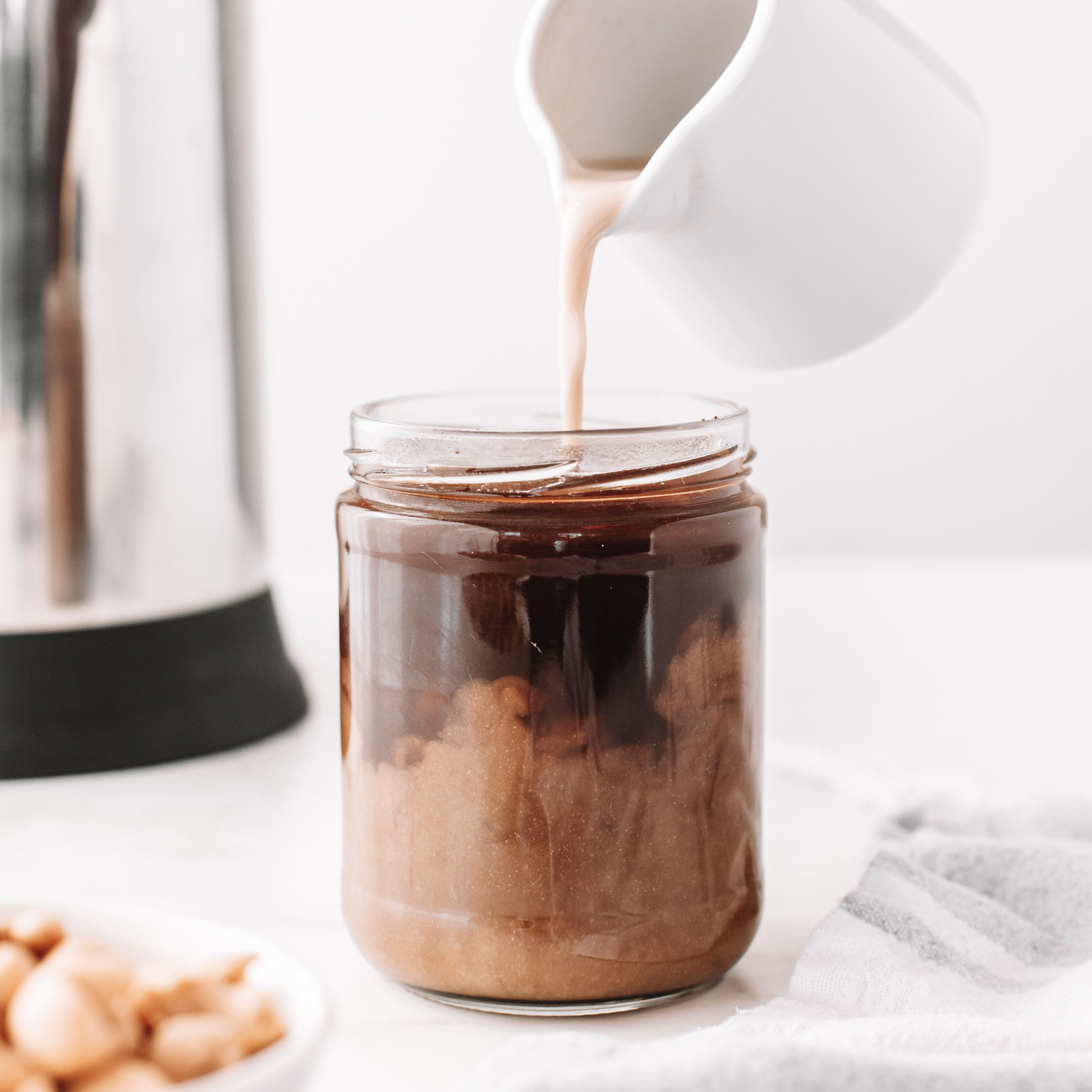 vegan Pumpkin Spice Creamer being poured into a coffee