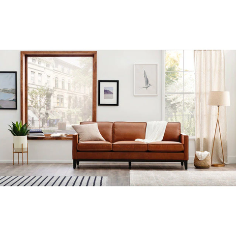 A brown leather sofa in a very well-decorated living room