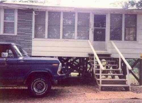 This 1978 Ford 4 x 4 pickup truck has a topper with a rack to carry Mr. Harbin's small aluminum boat.  In 1970 Mr. Harbin purchased the cabin.  The front porch had a roll-up canvas rain shield, later windows were installed as you can see.  Mr. Harbin did not remember the exact year when the Spring Flood of the White River when he tied his boat to the top step to look inside the cabin to see if there was any water damage.  The water did lap the underside of the floor but no water made it inside.  The Clarendon river gage read 34 to 35 feet.