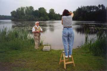 Ms. Kris Kandler (Corporate Photographer) is photographing the action at the Iola Pond while Mr. Harbin demonstrates casting and retrieving the red and white Heddon, River Runt Spook lure.