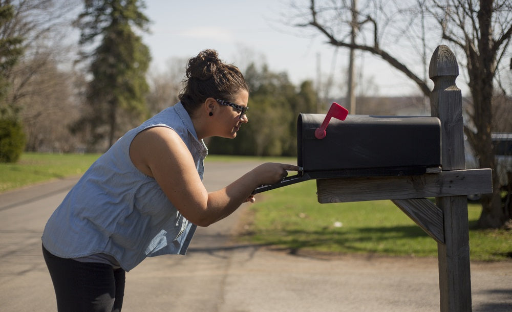 Attractive woman looks inside a mailbox