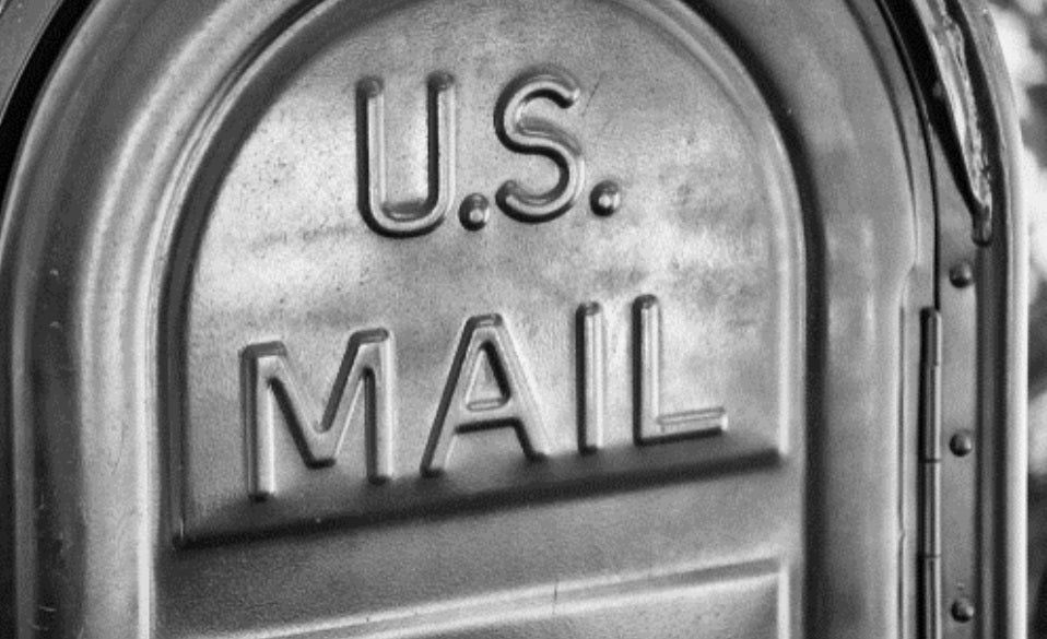 US Mail written on a metal mailbox