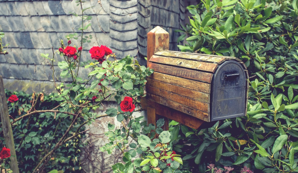 wooden mail box in flower garden