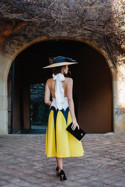 Miss Cavallier look de invitada de boda blanco y amarillo con zapatos negros de tacón salón ondas y dorado con tacón bañado en oro Just-ene