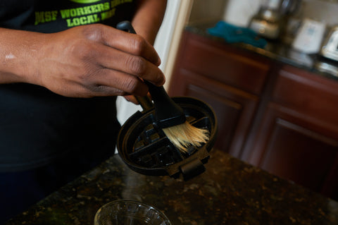 Applying a thin coat of oil on The Cast Iron Stuffed Waffle Iron