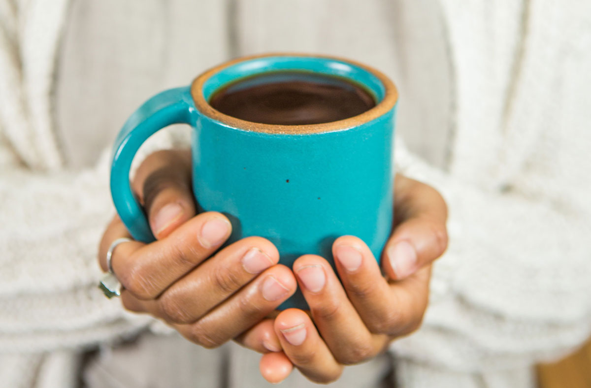 Hands holding a warm cup of coffee