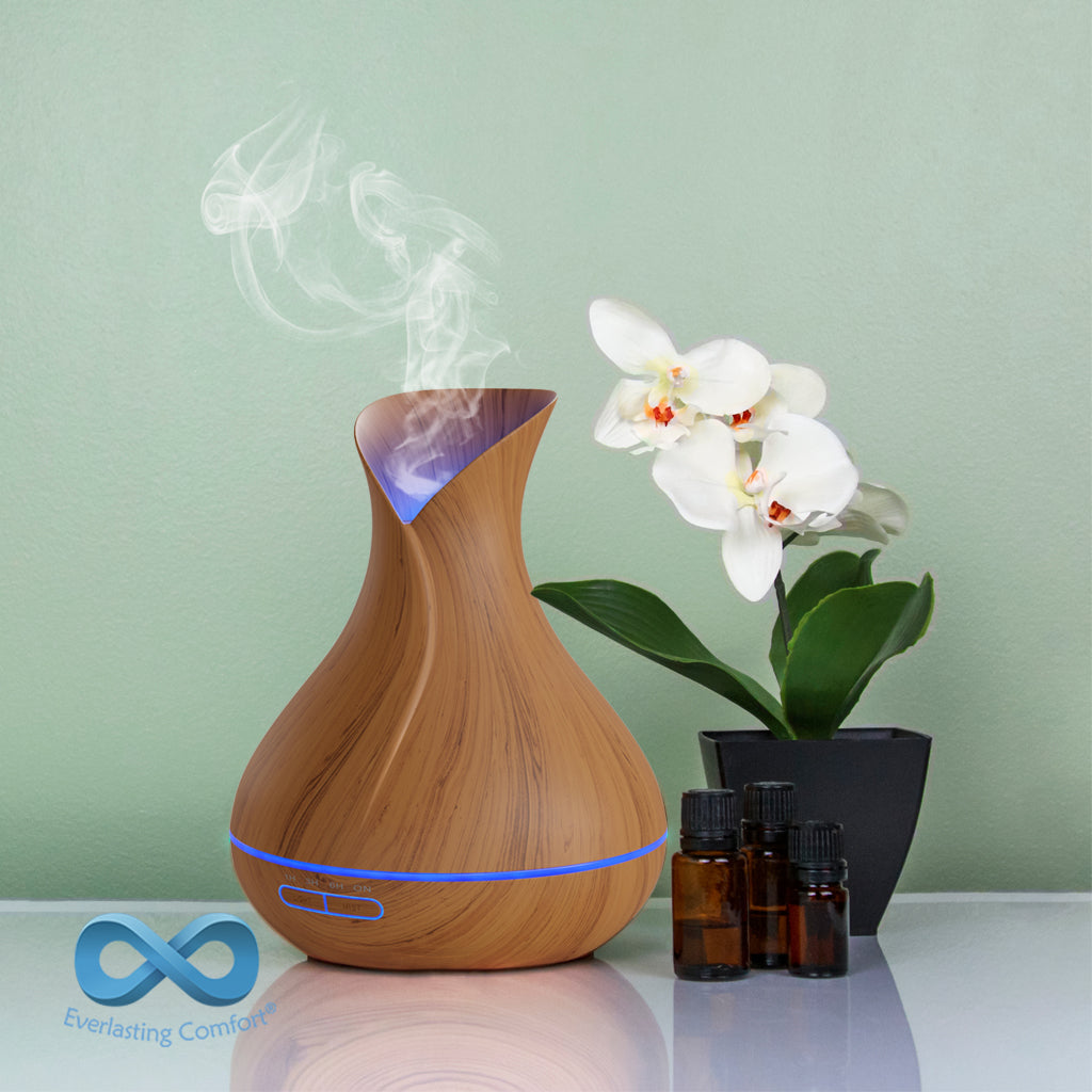 oil diffuser next to a flower on a green background
