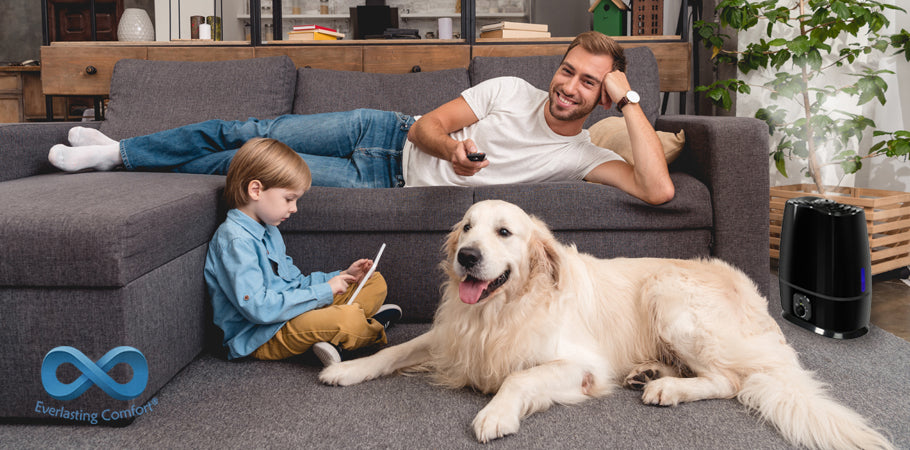 father watches TV on the couch, the child plays on the tablet, the dog sits nearby