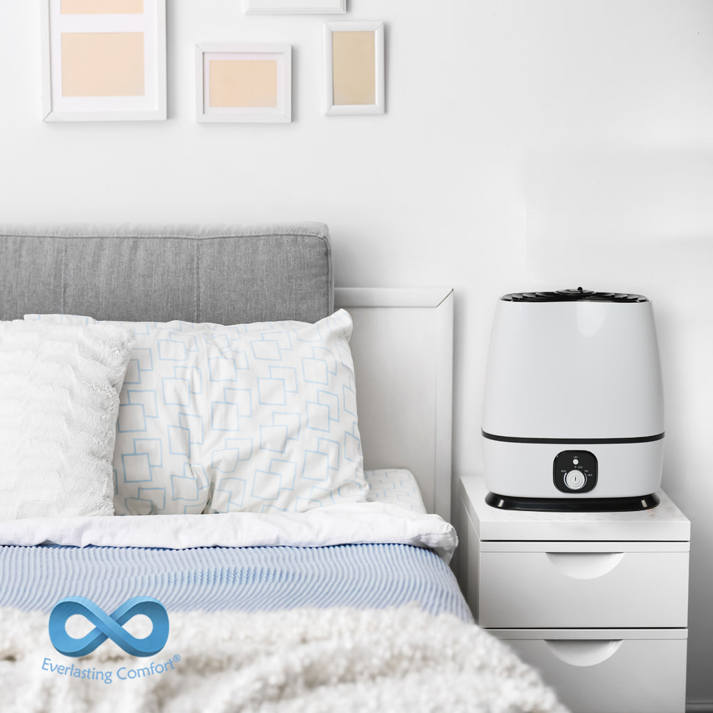 humidifier stands on the bedside table near the bed in a bright room 