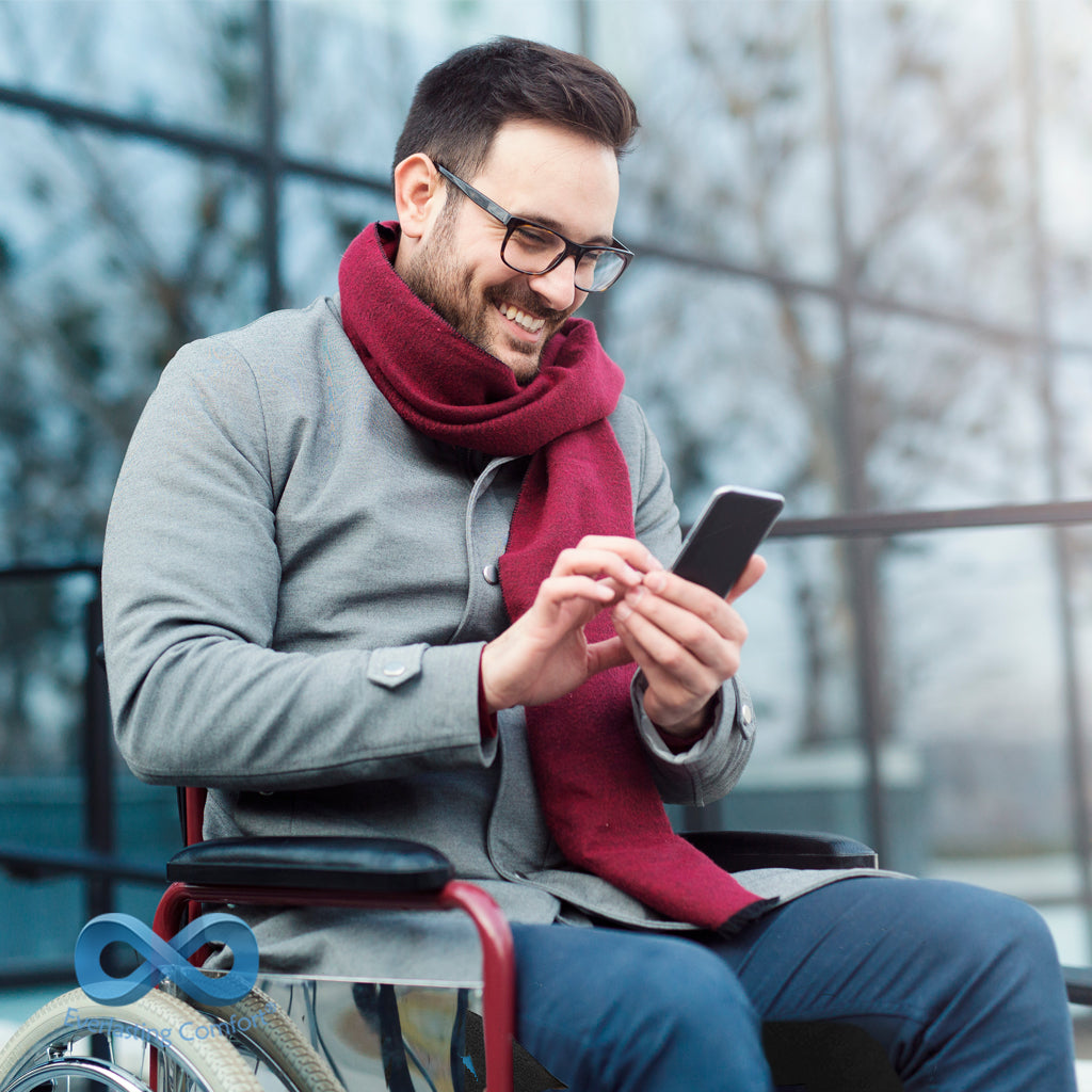 a man in a wheelchair looks at the phone and laughs