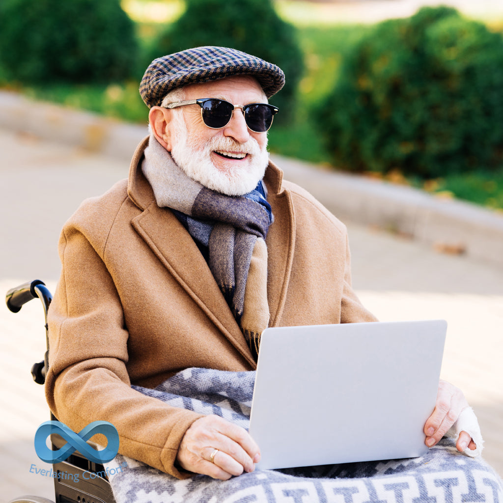 an elderly man in a wheelchair holds a laptop