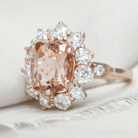 this stunning custom engagement ring has a morganite center stone and old european cut diamond halo 