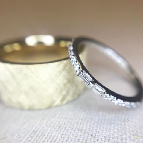 yellow gold chunky men's wedding band with a textured finish and a white gold women's diamond eternity band