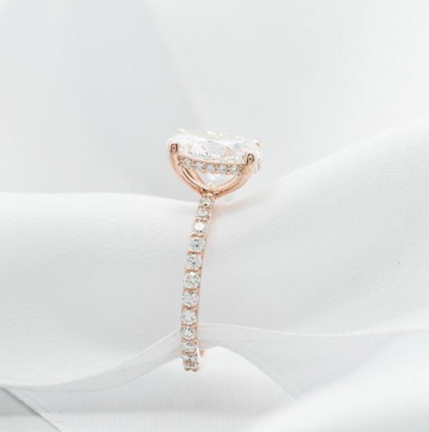 Oval diamond engagement ring with a rose gold diamond band and hidden diamond halo