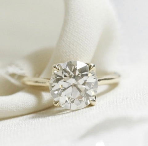 solitaire diamond engagement ring with an old european cut diamond set in 14k yellow gold with claw prongs